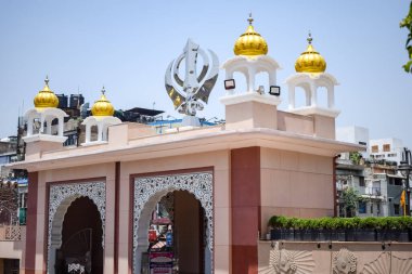 Gurudwara girişinde Khanda Sikh kutsal dini sembolü parlak mavi gökyüzü görüntüsüyle Chandni Chowk 'ta, Eski Delhi' deki Kızıl Kale 'nin karşısındaki Sis Ganj Sahib Gurudwara' da çekildi.