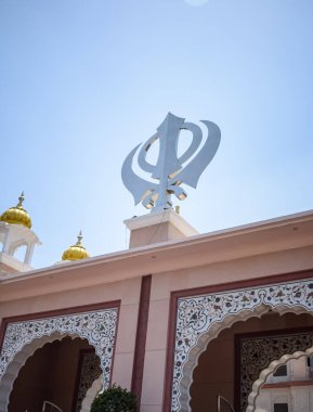Gurudwara girişinde Khanda Sikh kutsal dini sembolü parlak mavi gökyüzü görüntüsüyle Chandni Chowk 'ta, Eski Delhi' deki Kızıl Kale 'nin karşısındaki Sis Ganj Sahib Gurudwara' da çekildi.