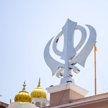 Gurudwara girişinde Khanda Sikh kutsal dini sembolü parlak mavi gökyüzü görüntüsüyle Chandni Chowk 'ta, Eski Delhi' deki Kızıl Kale 'nin karşısındaki Sis Ganj Sahib Gurudwara' da çekildi.