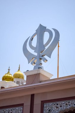 Gurudwara girişinde Khanda Sikh kutsal dini sembolü parlak mavi gökyüzü görüntüsüyle Chandni Chowk 'ta, Eski Delhi' deki Kızıl Kale 'nin karşısındaki Sis Ganj Sahib Gurudwara' da çekildi.