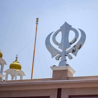 Gurudwara girişinde Khanda Sikh kutsal dini sembolü parlak mavi gökyüzü görüntüsüyle Chandni Chowk 'ta, Eski Delhi' deki Kızıl Kale 'nin karşısındaki Sis Ganj Sahib Gurudwara' da çekildi.