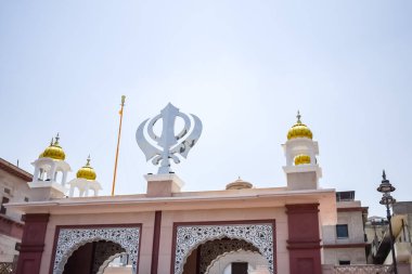Gurudwara girişinde Khanda Sikh kutsal dini sembolü parlak mavi gökyüzü görüntüsüyle Chandni Chowk 'ta, Eski Delhi' deki Kızıl Kale 'nin karşısındaki Sis Ganj Sahib Gurudwara' da çekildi.