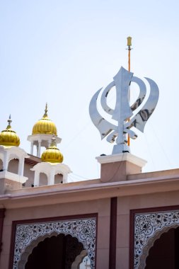 Gurudwara girişinde Khanda Sikh kutsal dini sembolü parlak mavi gökyüzü görüntüsüyle Chandni Chowk 'ta, Eski Delhi' deki Kızıl Kale 'nin karşısındaki Sis Ganj Sahib Gurudwara' da çekildi.