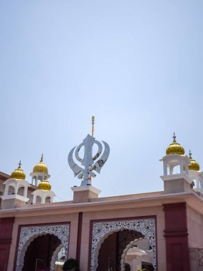 Gurudwara girişinde Khanda Sikh kutsal dini sembolü parlak mavi gökyüzü görüntüsüyle Chandni Chowk 'ta, Eski Delhi' deki Kızıl Kale 'nin karşısındaki Sis Ganj Sahib Gurudwara' da çekildi.
