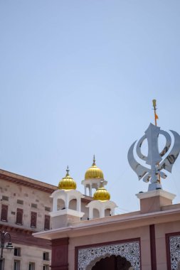 Gurudwara girişinde Khanda Sikh kutsal dini sembolü parlak mavi gökyüzü görüntüsüyle Chandni Chowk 'ta, Eski Delhi' deki Kızıl Kale 'nin karşısındaki Sis Ganj Sahib Gurudwara' da çekildi.