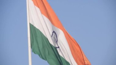India flag flying high at Connaught Place with pride in blue sky, India flag fluttering, Indian Flag on Independence Day and Republic Day of India, tilt up shot, Waving Indian flag, Har Ghar Tiranga