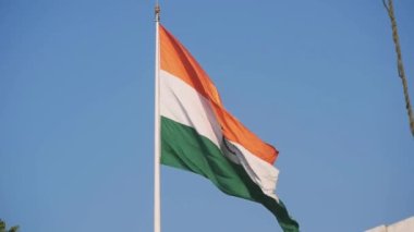 India flag flying high at Connaught Place with pride in blue sky, India flag fluttering, Indian Flag on Independence Day and Republic Day of India, tilt up shot, Waving Indian flag, Har Ghar Tiranga