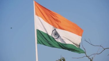 India flag flying high at Connaught Place with pride in blue sky, India flag fluttering, Indian Flag on Independence Day and Republic Day of India, tilt up shot, Waving Indian flag, Har Ghar Tiranga