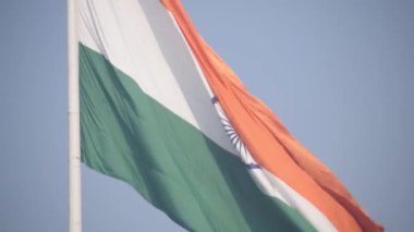 India flag flying high at Connaught Place with pride in blue sky, India flag fluttering, Indian Flag on Independence Day and Republic Day of India, tilt up shot, Waving Indian flag, Har Ghar Tiranga