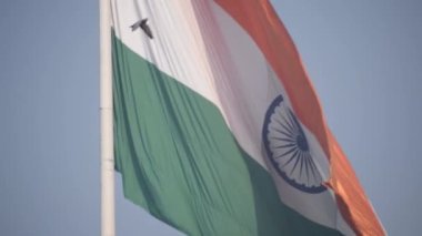 India flag flying high at Connaught Place with pride in blue sky, India flag fluttering, Indian Flag on Independence Day and Republic Day of India, tilt up shot, Waving Indian flag, Har Ghar Tiranga