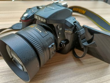 Yeni Delhi, Hindistan, 28 Mayıs 2023 - Nikon D5300 kamera 35 mm f2.8 asal lens düz arkaplanda, Nikon DSLR kamera çekimi