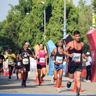 Yeni Delhi, Hindistan - 16 Ekim 2022 - Bitmek üzere olan maraton katılımcılarının bitiş çizgisini geçmek üzere olan Delhi Yarı Maratonu 2022