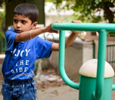 Asyalı çocuk sabah vakti sosyete parkında rutin egzersiz yapıyor. Kendini hayat boyu zinde tutmak için şirin bir çocuk egzersizi ve spor salonu. Açık havada çocuk egzersizi.