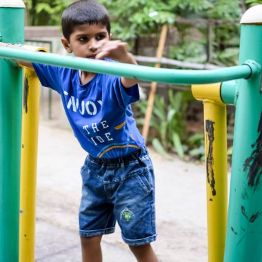 Asyalı çocuk sabah vakti sosyete parkında rutin egzersiz yapıyor. Kendini hayat boyu zinde tutmak için şirin bir çocuk egzersizi ve spor salonu. Açık havada çocuk egzersizi.
