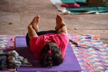 Hindistan, Yeni Delhi 'deki Lodhi Garden Park' ta yoga yapan Hintli genç bir kadından esinlendim. Genç vatandaş dışarıda egzersiz yapıyor ve yoga köşesinde duruyor. Spor salonu ve yaşam dengesi konsepti