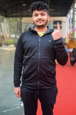 New Delhi, India - December 04 2022 - Unidentified people showing their ink-marked fingers after casting votes in front of polling booth of east Delhi area for MCD local body Elections 2022