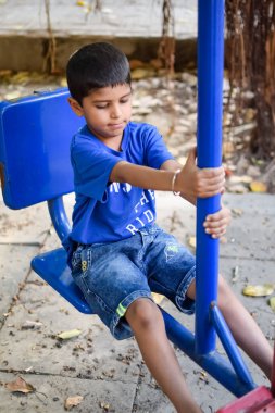 Sosyete parkında yoga pozu veren Asyalı zeki çocuk, çocuk yoga pozu. Yoga ve meditasyon yapan küçük çocuk..