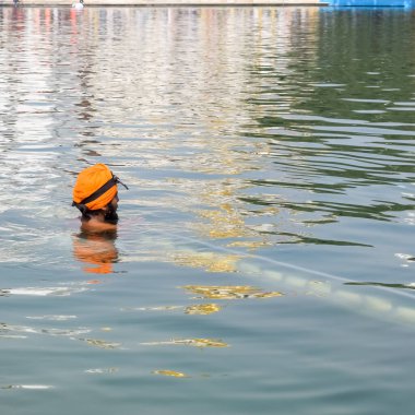 Amritsar, Hindistan - 26 Şubat 2023 - Amritsar, Punjab, Hindistan 'daki Altın Tapınak' ta (Harmandir Sahib) sarovarda kutsal dalış yapan tanımlanamayan dindarlar,