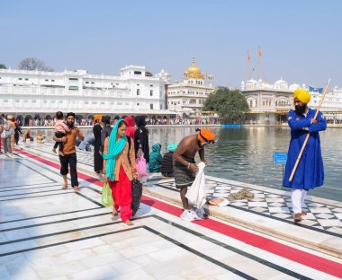 Amritsar, Hindistan - 26 Şubat 2023 - Amritsar, Punjab, Hindistan 'daki Altın Tapınak' ta (Harmandir Sahib) sarovarda kutsal dalış yapan tanımlanamayan dindarlar,