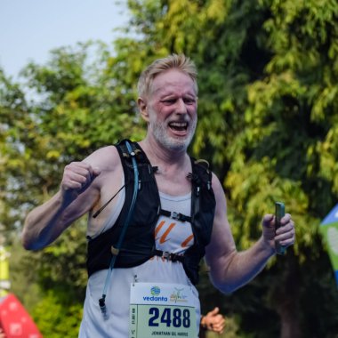 Yeni Delhi, Hindistan - 16 Ekim 2022 - Bitmek üzere olan maraton katılımcılarının bitiş çizgisini geçmek üzere olan Delhi Yarı Maratonu 2022