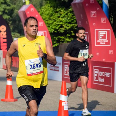 Yeni Delhi, Hindistan - 16 Ekim 2022 - Bitmek üzere olan maraton katılımcılarının bitiş çizgisini geçmek üzere olan Delhi Yarı Maratonu 2022