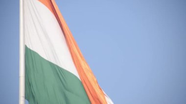 India flag flying high at Connaught Place with pride in blue sky, India flag fluttering, Indian Flag on Independence Day and Republic Day of India, tilt up shot, Waving Indian flag, Har Ghar Tiranga