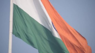 India flag flying high at Connaught Place with pride in blue sky, India flag fluttering, Indian Flag on Independence Day and Republic Day of India, tilt up shot, Waving Indian flag, Har Ghar Tiranga