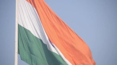 India flag flying high at Connaught Place with pride in blue sky, India flag fluttering, Indian Flag on Independence Day and Republic Day of India, tilt up shot, Waving Indian flag, Har Ghar Tiranga