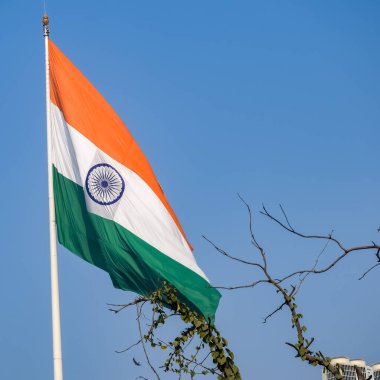 India flag flying high at Connaught Place with pride in blue sky, India flag fluttering, Indian Flag on Independence Day and Republic Day of India, tilt up shot, Waving Indian flag, Har Ghar Tiranga