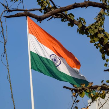 India flag flying high at Connaught Place with pride in blue sky, India flag fluttering, Indian Flag on Independence Day and Republic Day of India, tilt up shot, Waving Indian flag, Har Ghar Tiranga