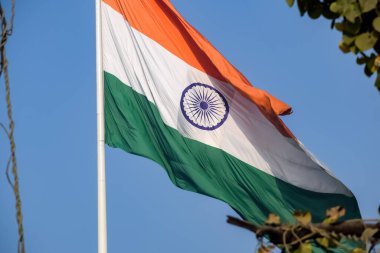 India flag flying high at Connaught Place with pride in blue sky, India flag fluttering, Indian Flag on Independence Day and Republic Day of India, tilt up shot, Waving Indian flag, Har Ghar Tiranga