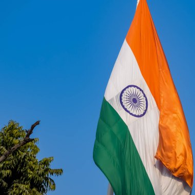 India flag flying high at Connaught Place with pride in blue sky, India flag fluttering, Indian Flag on Independence Day and Republic Day of India, tilt up shot, Waving Indian flag, Har Ghar Tiranga