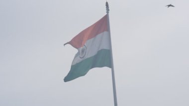 India flag flying high at Connaught Place with pride in blue sky, India flag fluttering, Indian Flag on Independence Day and Republic Day of India, tilt up shot, Waving Indian flag, Har Ghar Tiranga