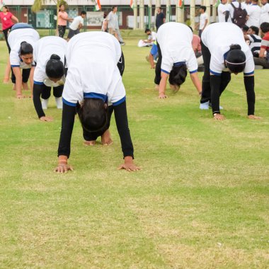 Yeni Delhi, Hindistan, 21 Haziran 2023 - Uluslararası Yoga Günü 'nde Delhi' deki Yamuna Spor Kompleksi 'nde grup Yoga egzersiz oturumu, kriket stadyumunda yoga derslerine katılan büyük bir grup yetişkin