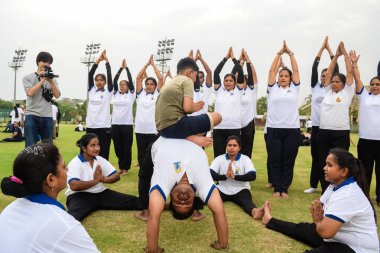 Yeni Delhi, Hindistan, 21 Haziran 2023 - Uluslararası Yoga Günü 'nde Delhi' deki Yamuna Spor Kompleksi 'nde grup Yoga egzersiz oturumu, kriket stadyumunda yoga derslerine katılan büyük bir grup yetişkin