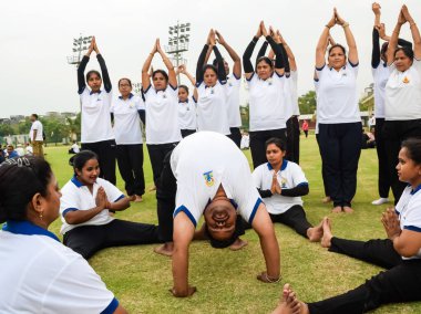 Yeni Delhi, Hindistan, 21 Haziran 2023 - Uluslararası Yoga Günü 'nde Delhi' deki Yamuna Spor Kompleksi 'nde grup Yoga egzersiz oturumu, kriket stadyumunda yoga derslerine katılan büyük bir grup yetişkin