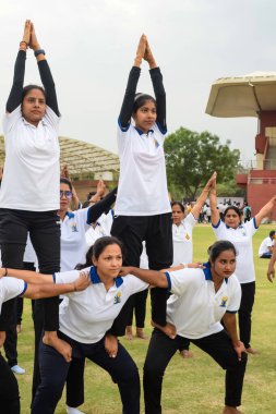 Yeni Delhi, Hindistan, 21 Haziran 2023 - Uluslararası Yoga Günü 'nde Delhi' deki Yamuna Spor Kompleksi 'nde grup Yoga egzersiz oturumu, kriket stadyumunda yoga derslerine katılan büyük bir grup yetişkin