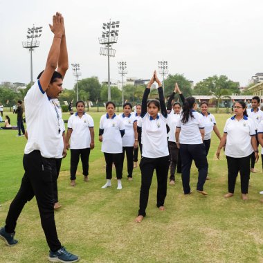 Yeni Delhi, Hindistan, 21 Haziran 2023 - Uluslararası Yoga Günü 'nde Delhi' deki Yamuna Spor Kompleksi 'nde grup Yoga egzersiz oturumu, kriket stadyumunda yoga derslerine katılan büyük bir grup yetişkin