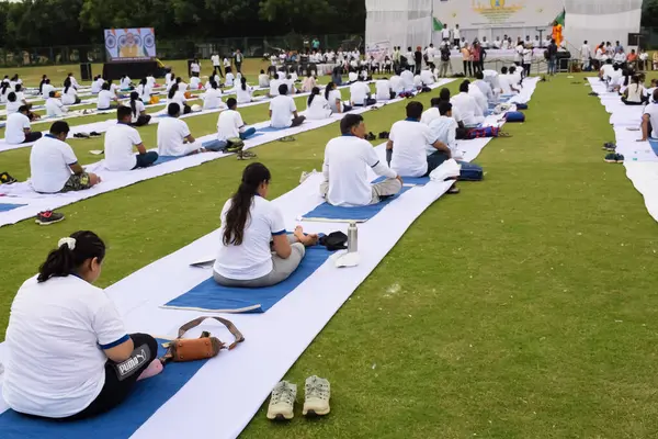 stock image New Delhi, India, June 21, 2023 - Group Yoga exercise session for people at Yamuna Sports Complex in Delhi on International Yoga Day, Big group of adults attending yoga class in cricket stadium