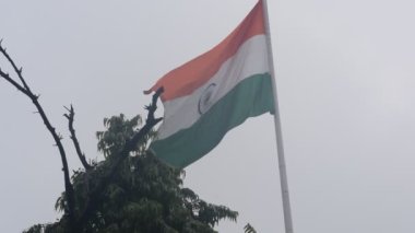 India flag flying high at Connaught Place with pride in blue sky, India flag fluttering, Indian Flag on Independence Day and Republic Day of India, tilt up shot, Waving Indian flag, Har Ghar Tiranga