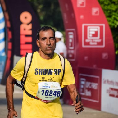 Yeni Delhi, Hindistan - 16 Ekim 2022 - Bitmek üzere olan maraton katılımcılarının bitiş çizgisini geçmek üzere olan Delhi Yarı Maratonu 2022