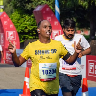 Yeni Delhi, Hindistan - 16 Ekim 2022 - Bitmek üzere olan maraton katılımcılarının bitiş çizgisini geçmek üzere olan Delhi Yarı Maratonu 2022