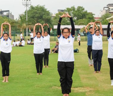 Yeni Delhi, Hindistan, 21 Haziran 2023 - Uluslararası Yoga Günü 'nde Delhi' deki Yamuna Spor Kompleksi 'nde grup Yoga egzersiz oturumu, kriket stadyumunda yoga derslerine katılan büyük bir grup yetişkin