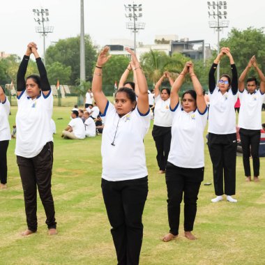 Yeni Delhi, Hindistan, 21 Haziran 2023 - Uluslararası Yoga Günü 'nde Delhi' deki Yamuna Spor Kompleksi 'nde grup Yoga egzersiz oturumu, kriket stadyumunda yoga derslerine katılan büyük bir grup yetişkin