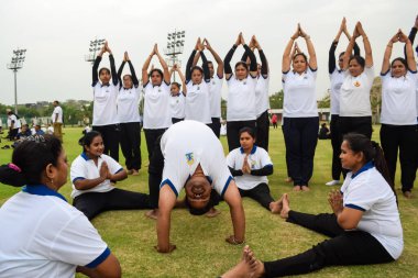 Yeni Delhi, Hindistan, 21 Haziran 2023 - Uluslararası Yoga Günü 'nde Delhi' deki Yamuna Spor Kompleksi 'nde grup Yoga egzersiz oturumu, kriket stadyumunda yoga derslerine katılan büyük bir grup yetişkin