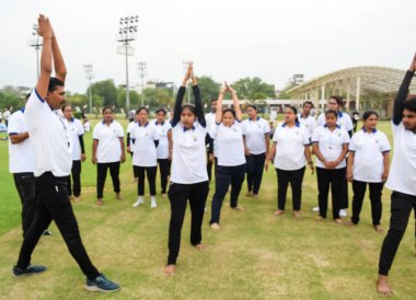 Yeni Delhi, Hindistan, 21 Haziran 2023 - Uluslararası Yoga Günü 'nde Delhi' deki Yamuna Spor Kompleksi 'nde grup Yoga egzersiz oturumu, kriket stadyumunda yoga derslerine katılan büyük bir grup yetişkin