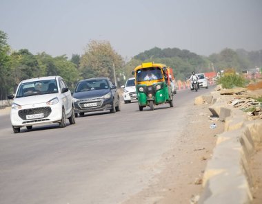 Yeni Delhi, Hindistan - 16 Nisan 2023 - Indra Gandhi Uluslararası Havalimanı yakınlarındaki ana yoldan geçen araçların görüntüsü