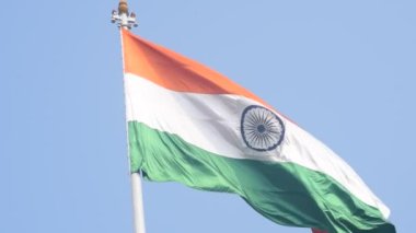 India flag flying high at Connaught Place with pride in blue sky, India flag fluttering, Indian Flag on Independence Day and Republic Day of India, tilt up shot, Waving Indian flag, Har Ghar Tiranga