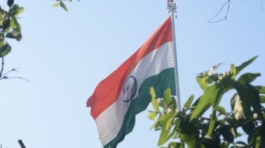 India flag flying high at Connaught Place with pride in blue sky, India flag fluttering, Indian Flag on Independence Day and Republic Day of India, tilt up shot, Waving Indian flag, Har Ghar Tiranga