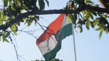 India flag flying high at Connaught Place with pride in blue sky, India flag fluttering, Indian Flag on Independence Day and Republic Day of India, tilt up shot, Waving Indian flag, Har Ghar Tiranga